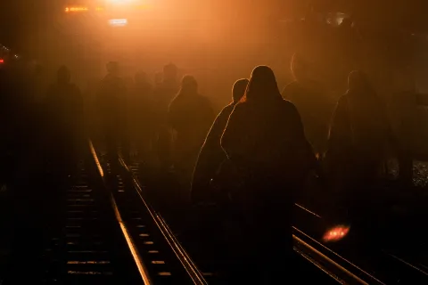 Image of migrants moving along the railway tracks.